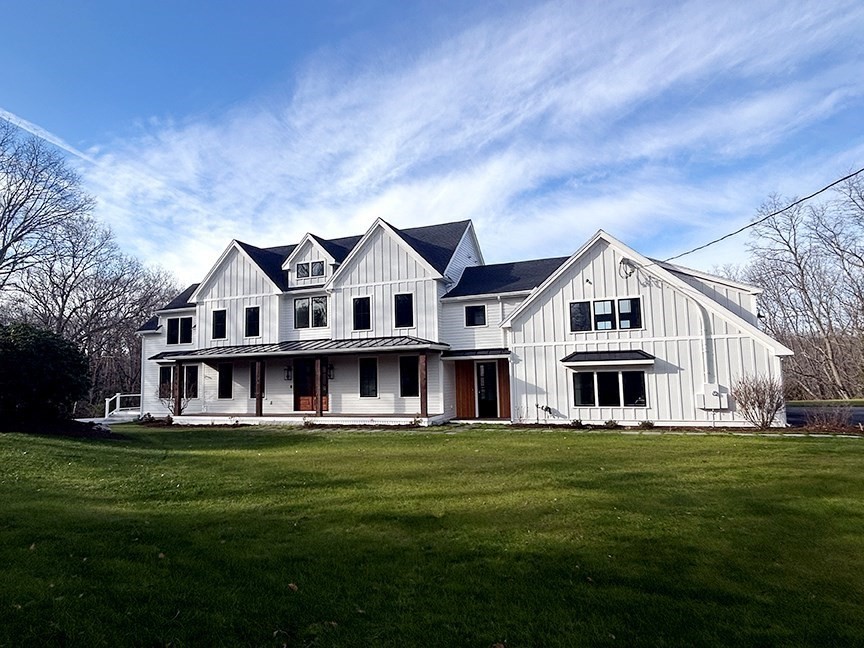 a front view of a house with a garden and trees