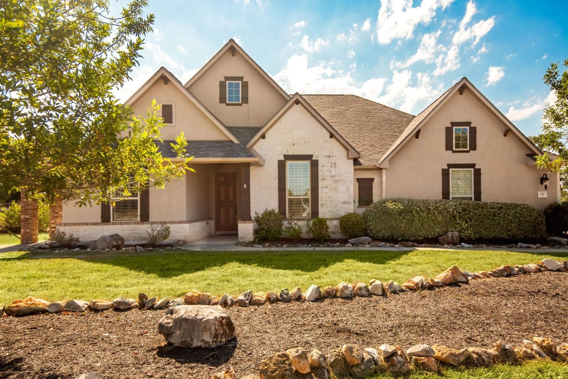 a view of a house with a big yard and large tree