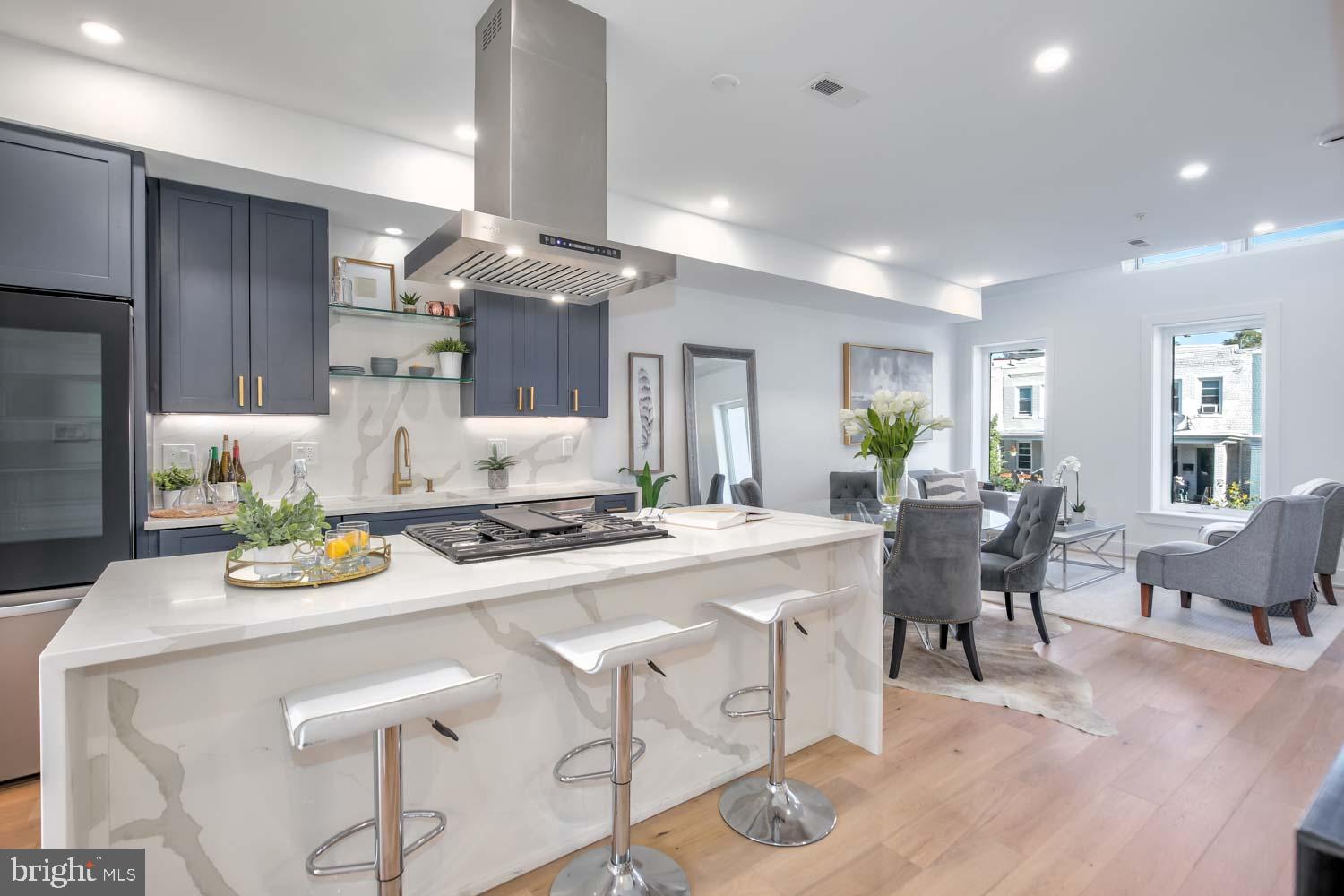 a kitchen with a dining table chairs stove and wooden floor