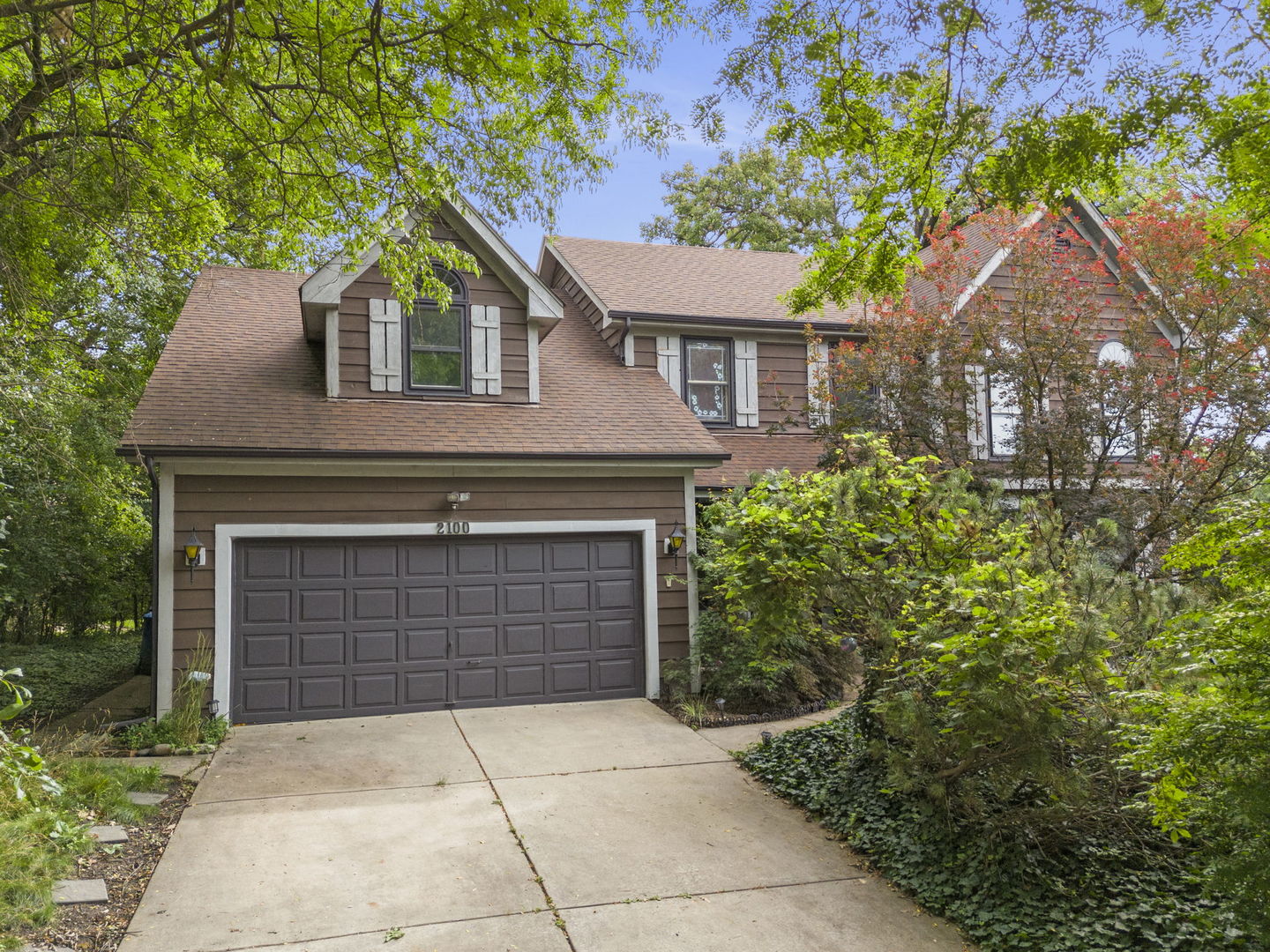 a front view of a house with yard and trees