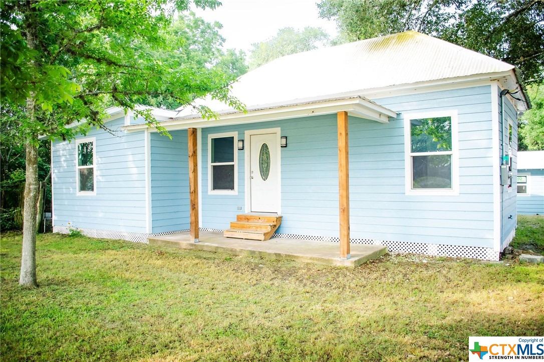 a backyard of a house with table and chairs