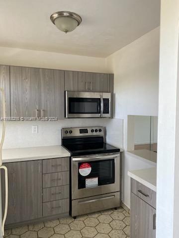 a kitchen with granite countertop a stove microwave and sink