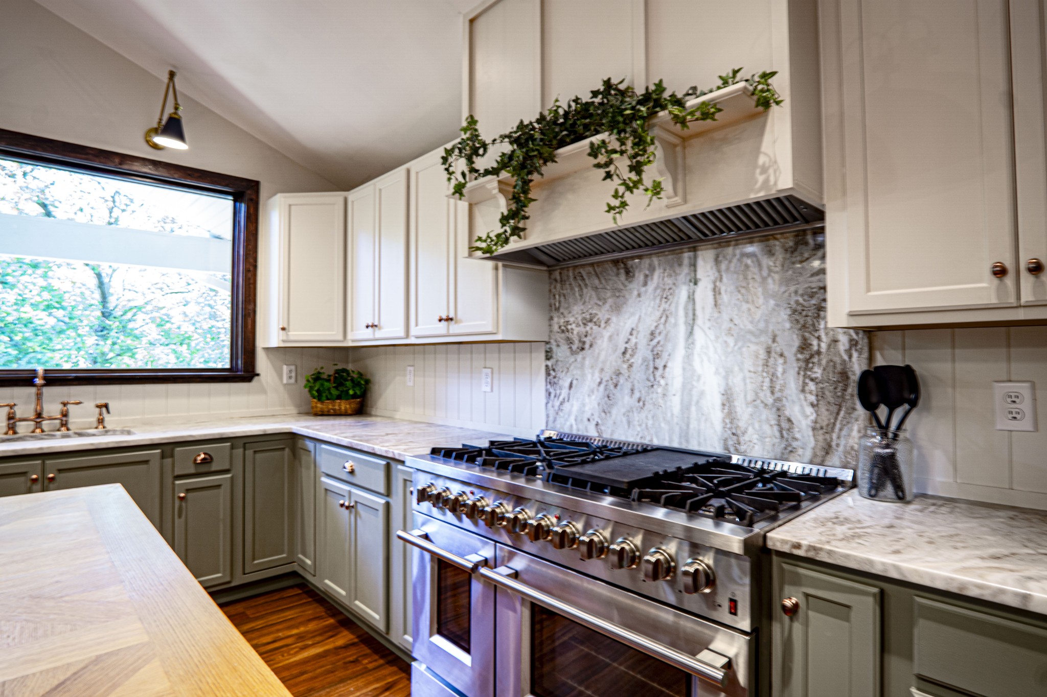 a kitchen with stainless steel appliances a sink a stove and a window