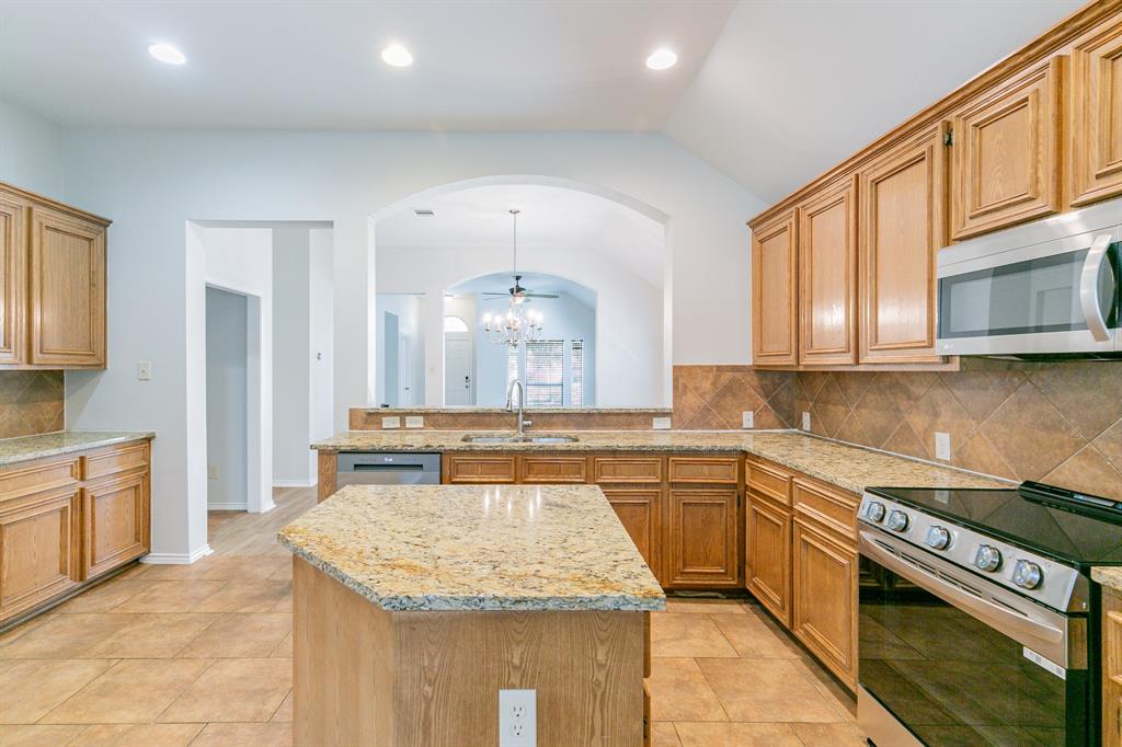 a kitchen with stainless steel appliances granite countertop a sink stove and cabinets