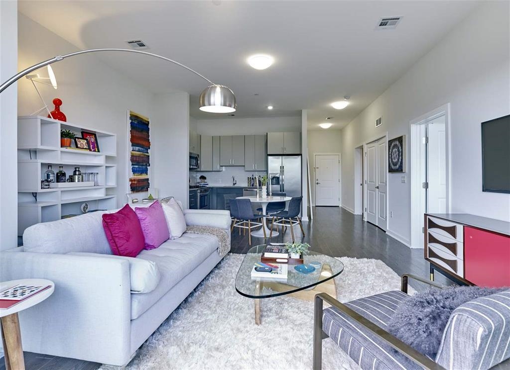 a living room with furniture kitchen and a table