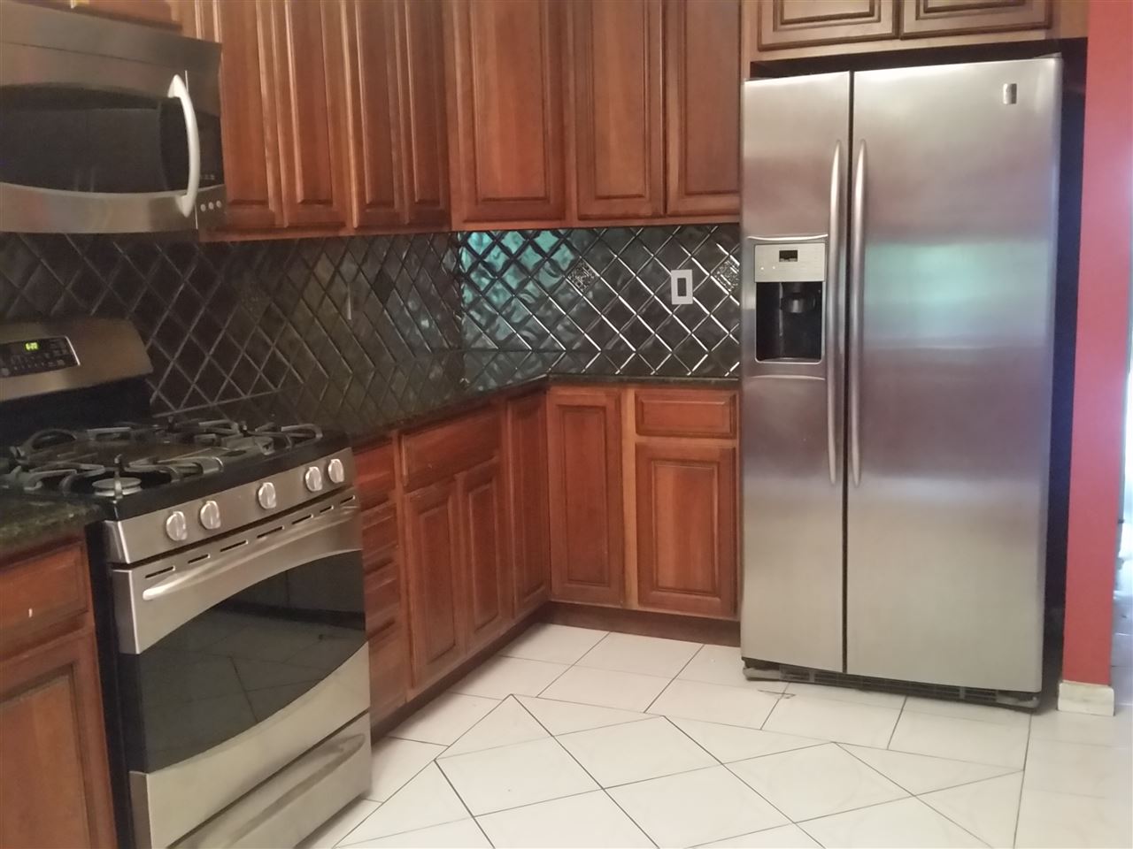 a kitchen with a refrigerator stove and cabinets