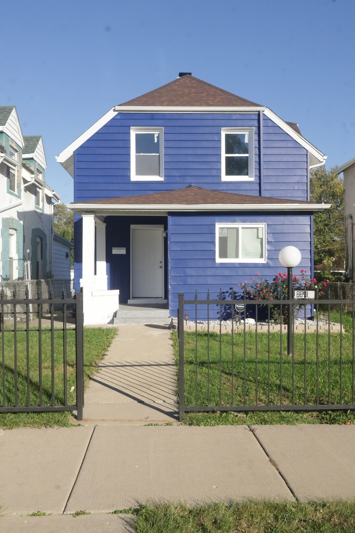 a brick house that has a small yard in front of it