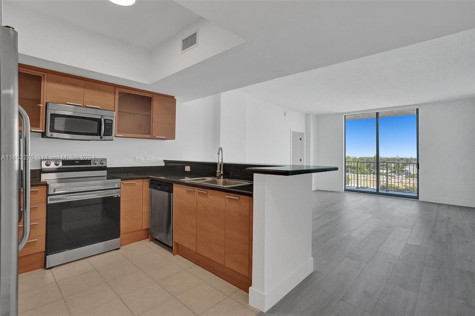 a kitchen with stainless steel appliances granite countertop a refrigerator and a stove top oven