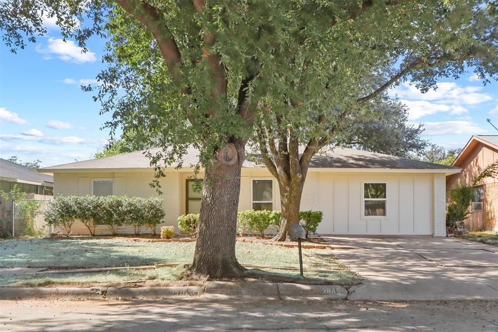 a view of a house with a tree in front of it