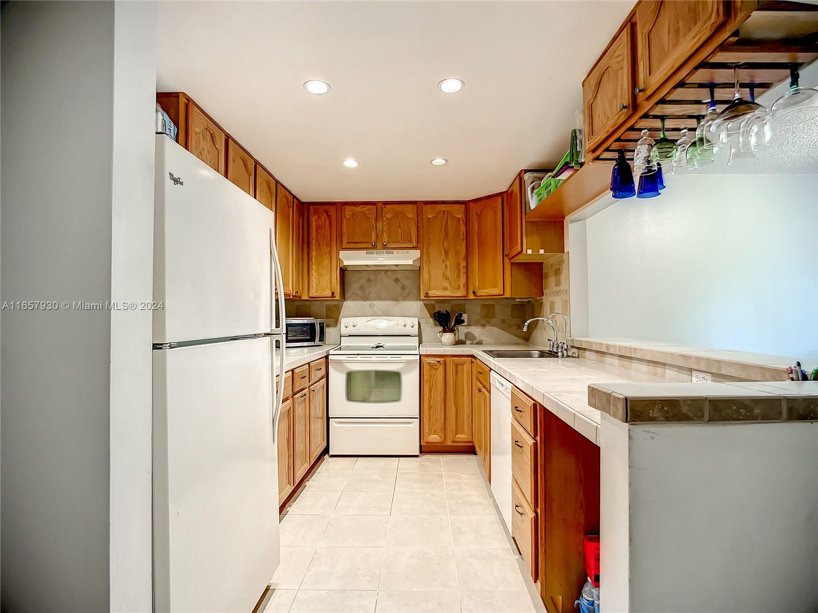 a kitchen with a refrigerator a stove top oven a sink and dishwasher