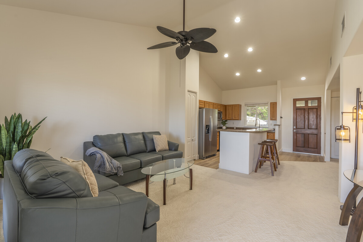 a living room with furniture and a dining table with a sink