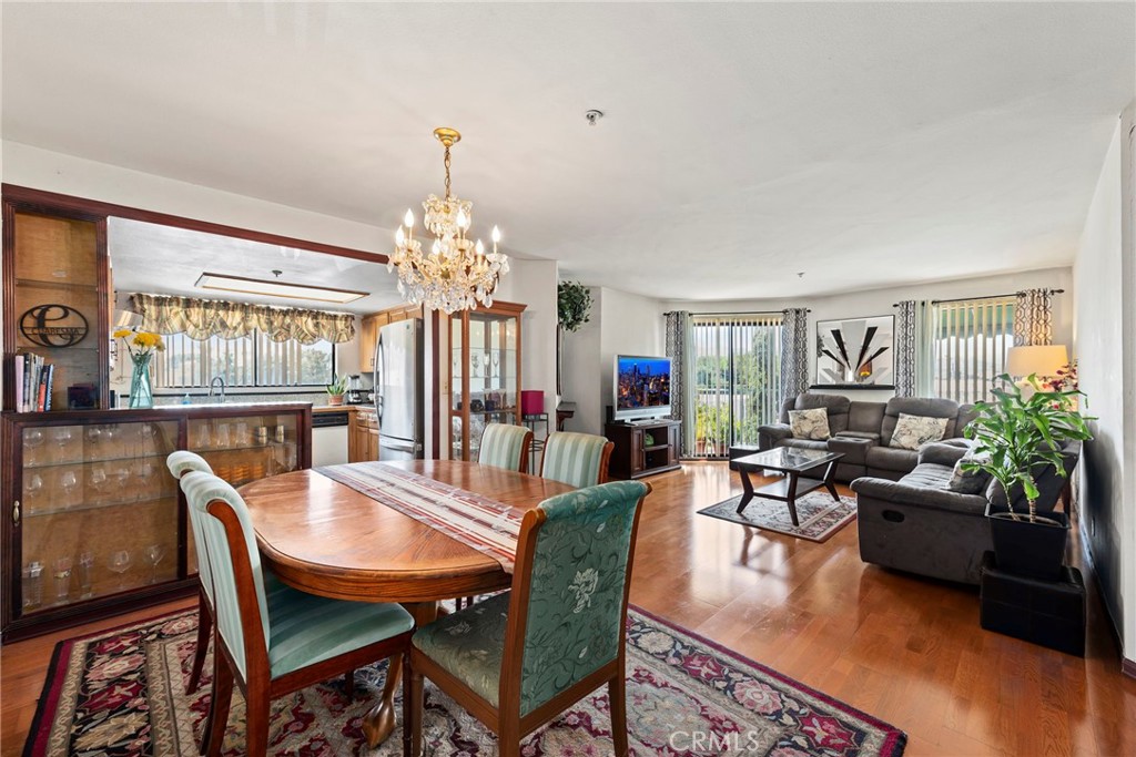 a dining room with wooden floor a chandelier a wooden table and chairs