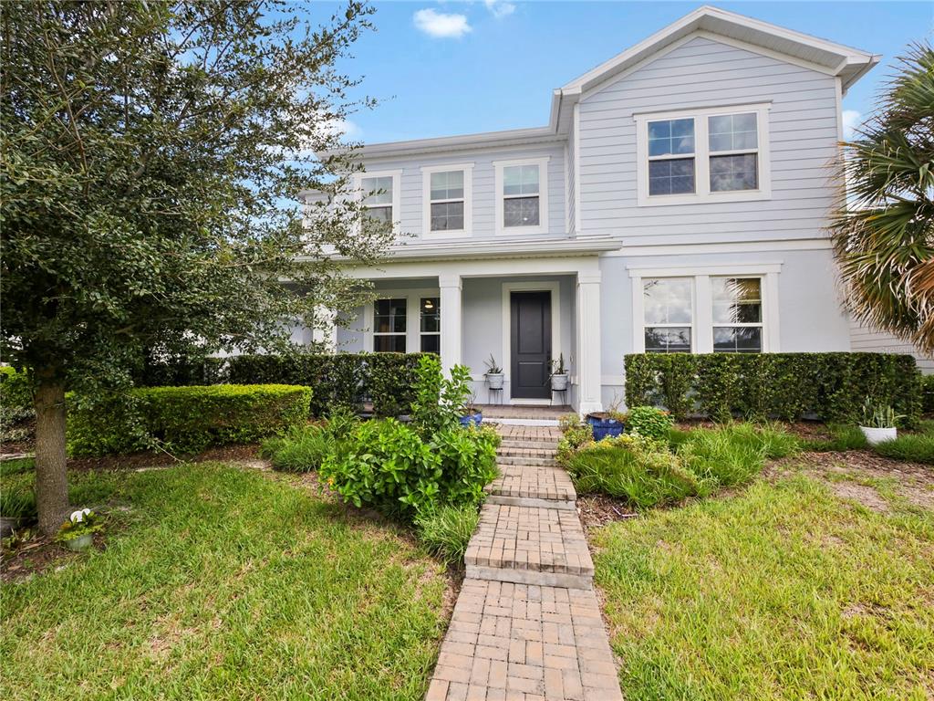 a front view of a house with a yard and potted plants