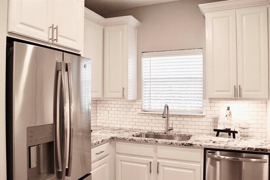 a kitchen with stainless steel appliances granite countertop a refrigerator and a sink