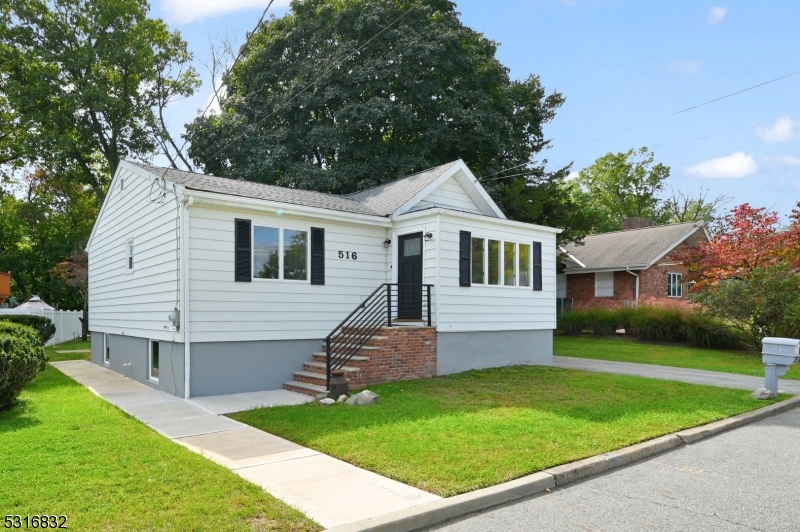 a front view of a house with a garden and yard