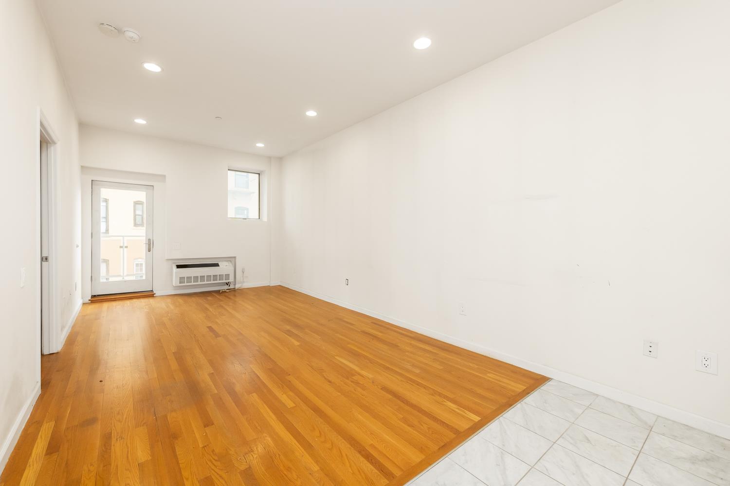 a view of empty room with wooden floor