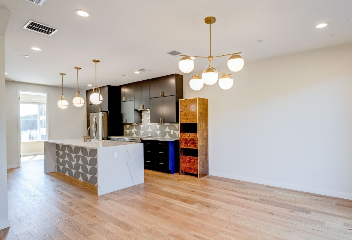 a large kitchen with stainless steel appliances a large island in the center