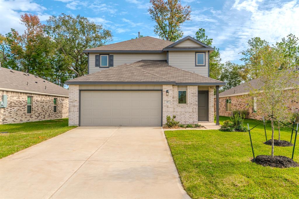 a front view of a house with a yard and garage