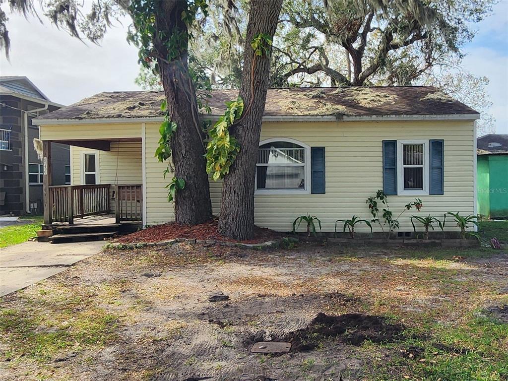 a view of a house with backyard and trees