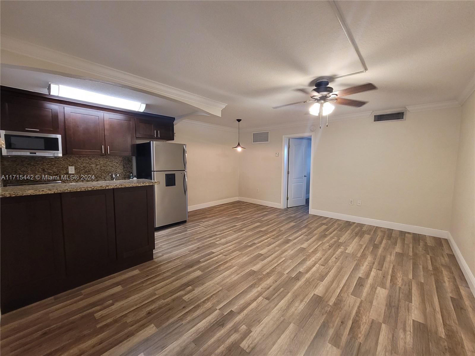 a view of a kitchen with a sink cabinets and wooden floor