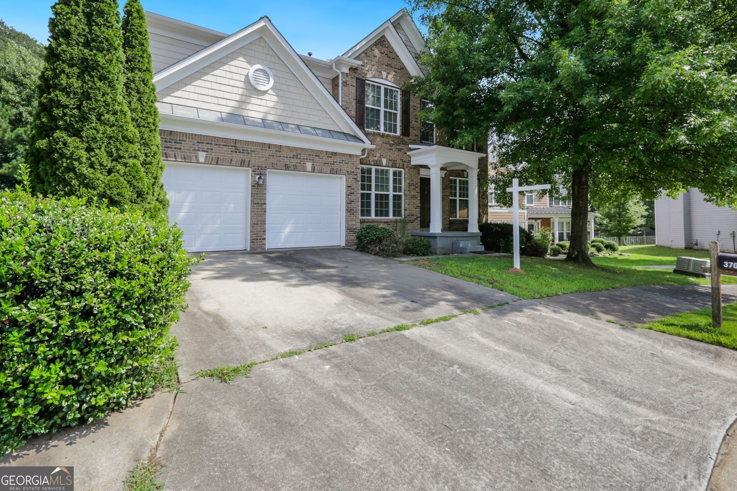 front view of a house with a yard and a trees