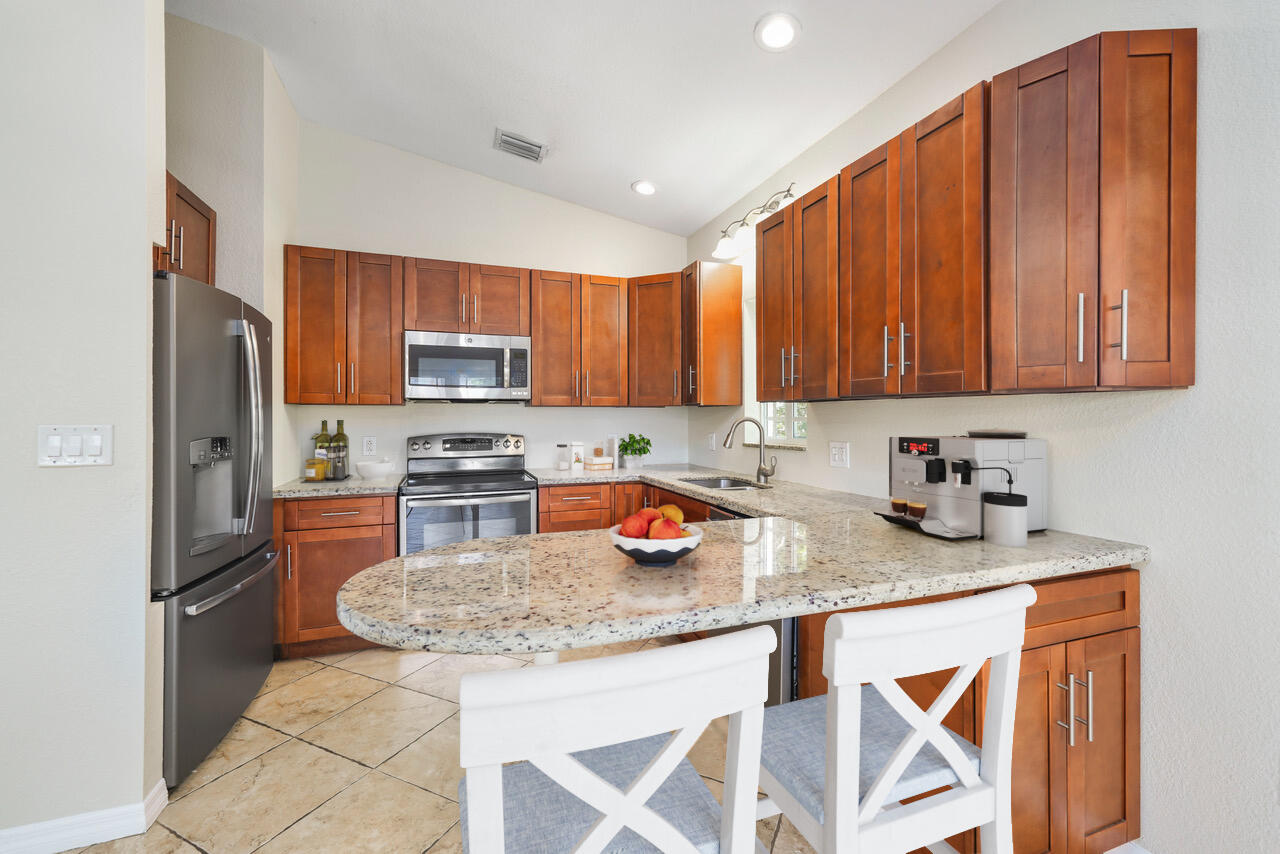 a kitchen with stainless steel appliances granite countertop a sink refrigerator and cabinets