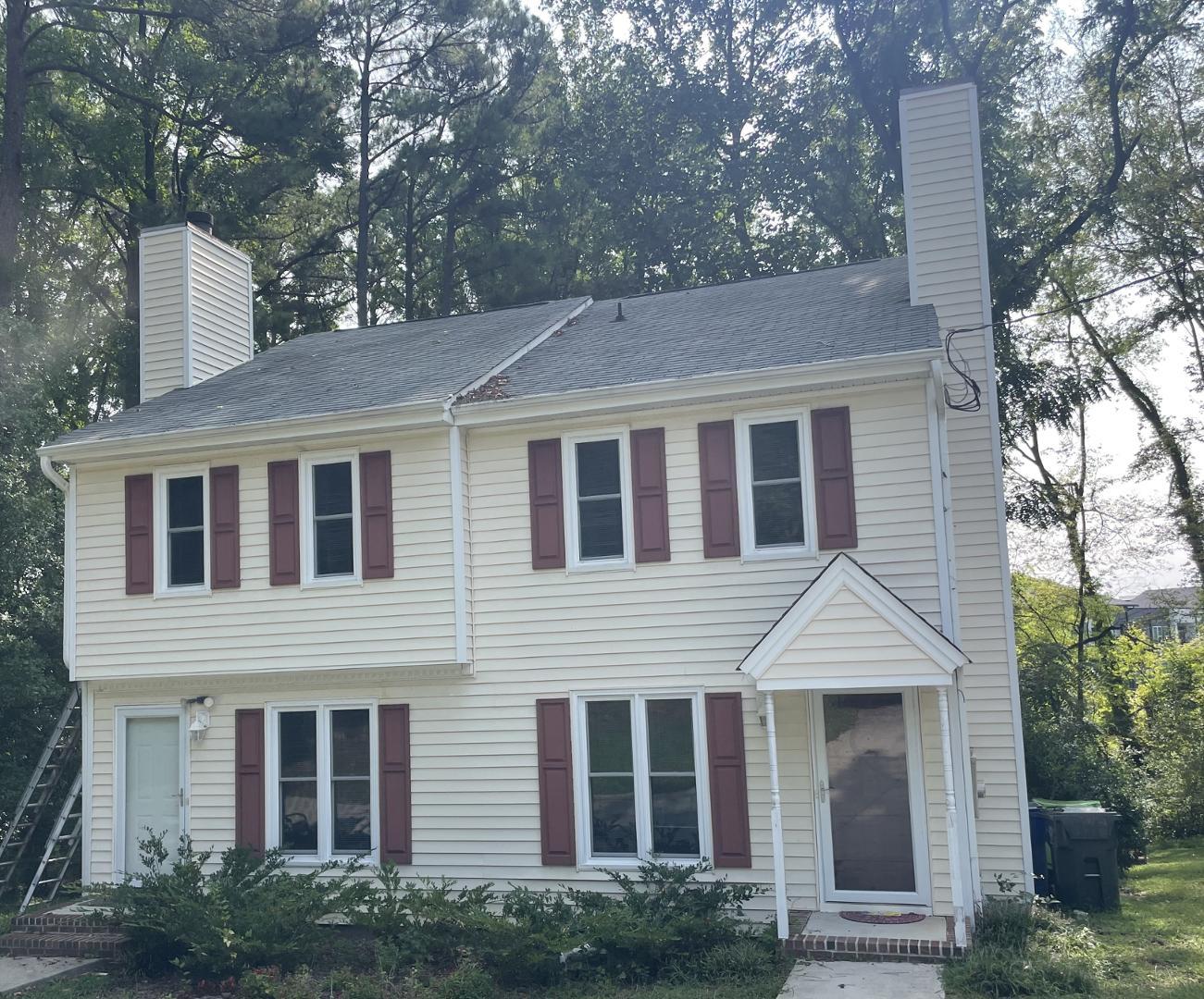 a front view of a house with plants and trees