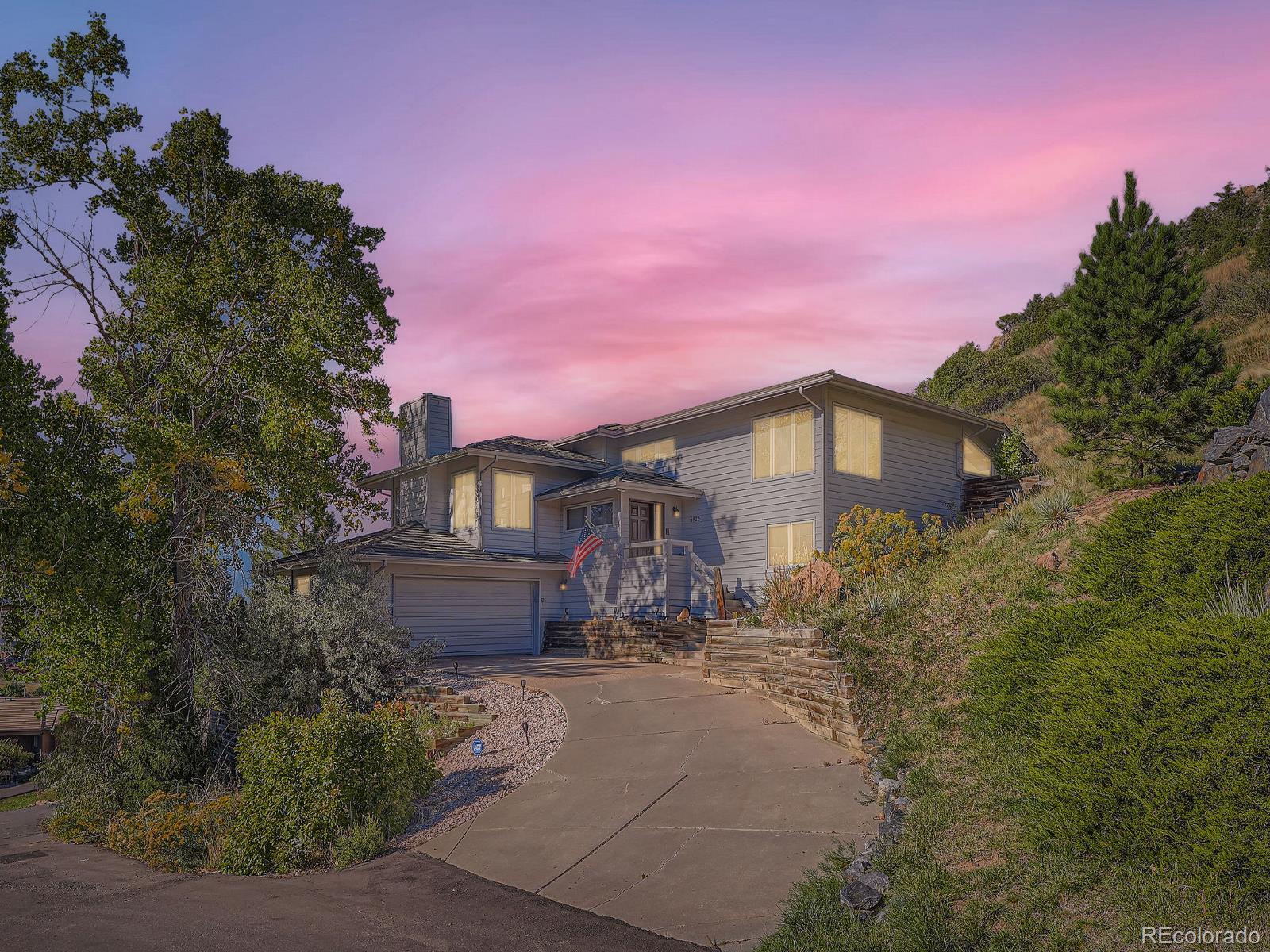 a front view of a house with a yard and tree s