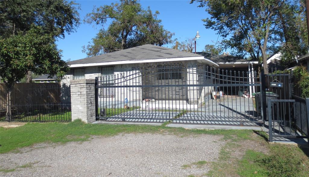 a view of a house with a small yard and a large tree