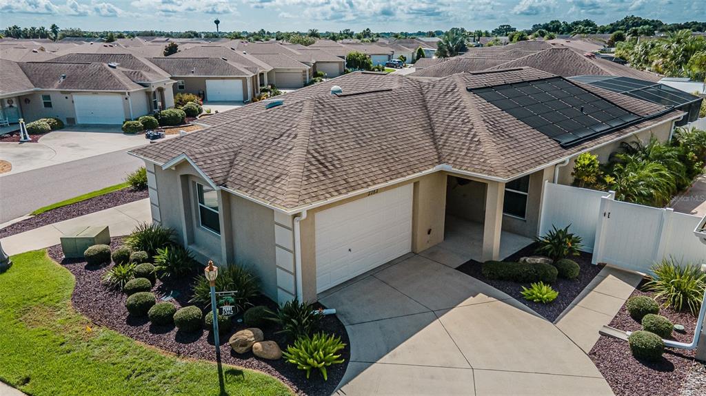 an aerial view of a house with yard and seating space