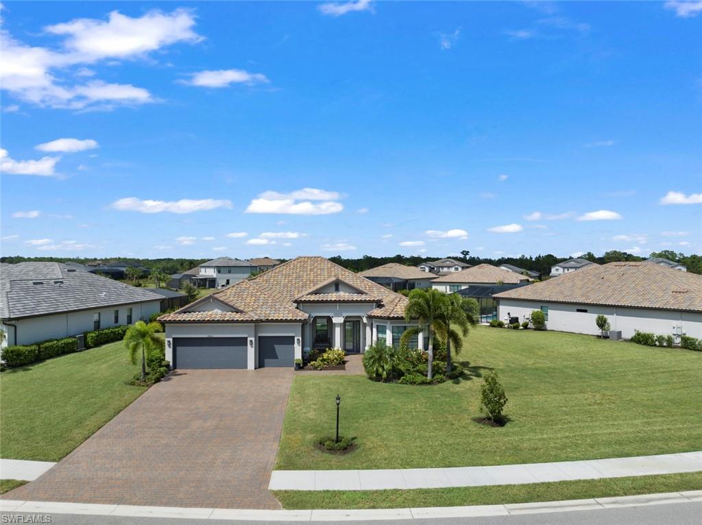 View of front of house featuring a garage and a front lawn