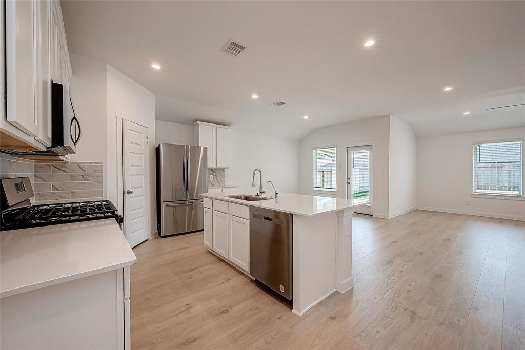 a kitchen with stainless steel appliances granite countertop a sink stove and refrigerator