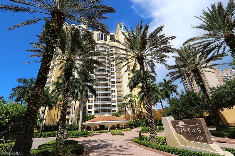 a view of a street with a building and palm trees