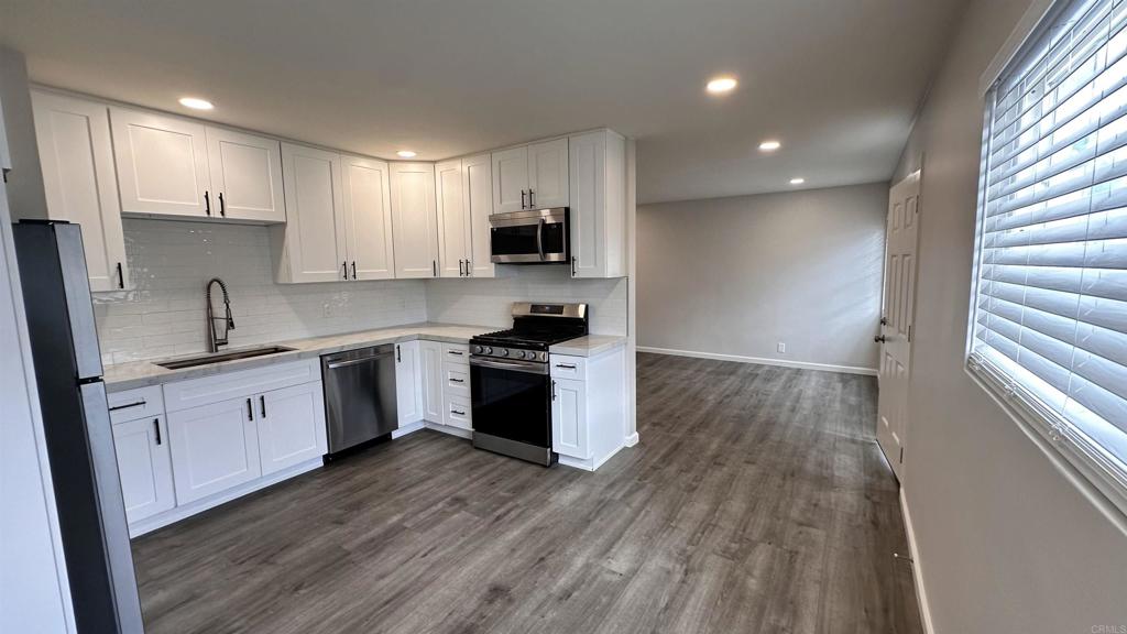 a kitchen with a sink a stove a refrigerator and cabinets