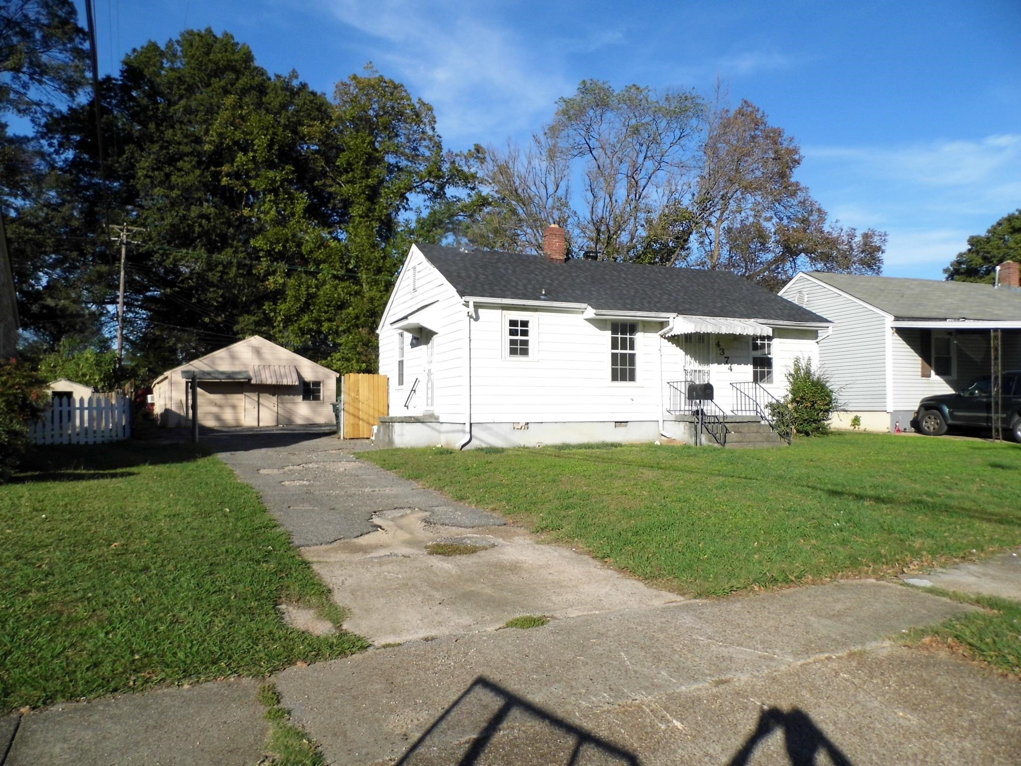 View of front of house featuring an outdoor structure and a front yard