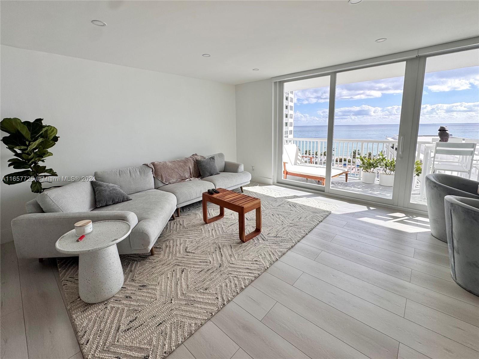 a living room with furniture and a large window with outer view