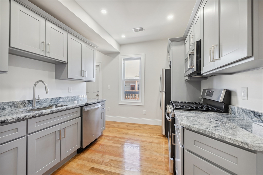 a kitchen with stainless steel appliances granite countertop a sink stove and cabinets