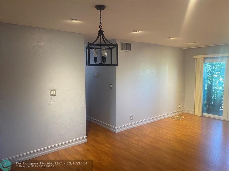 a view of empty room with wooden floor