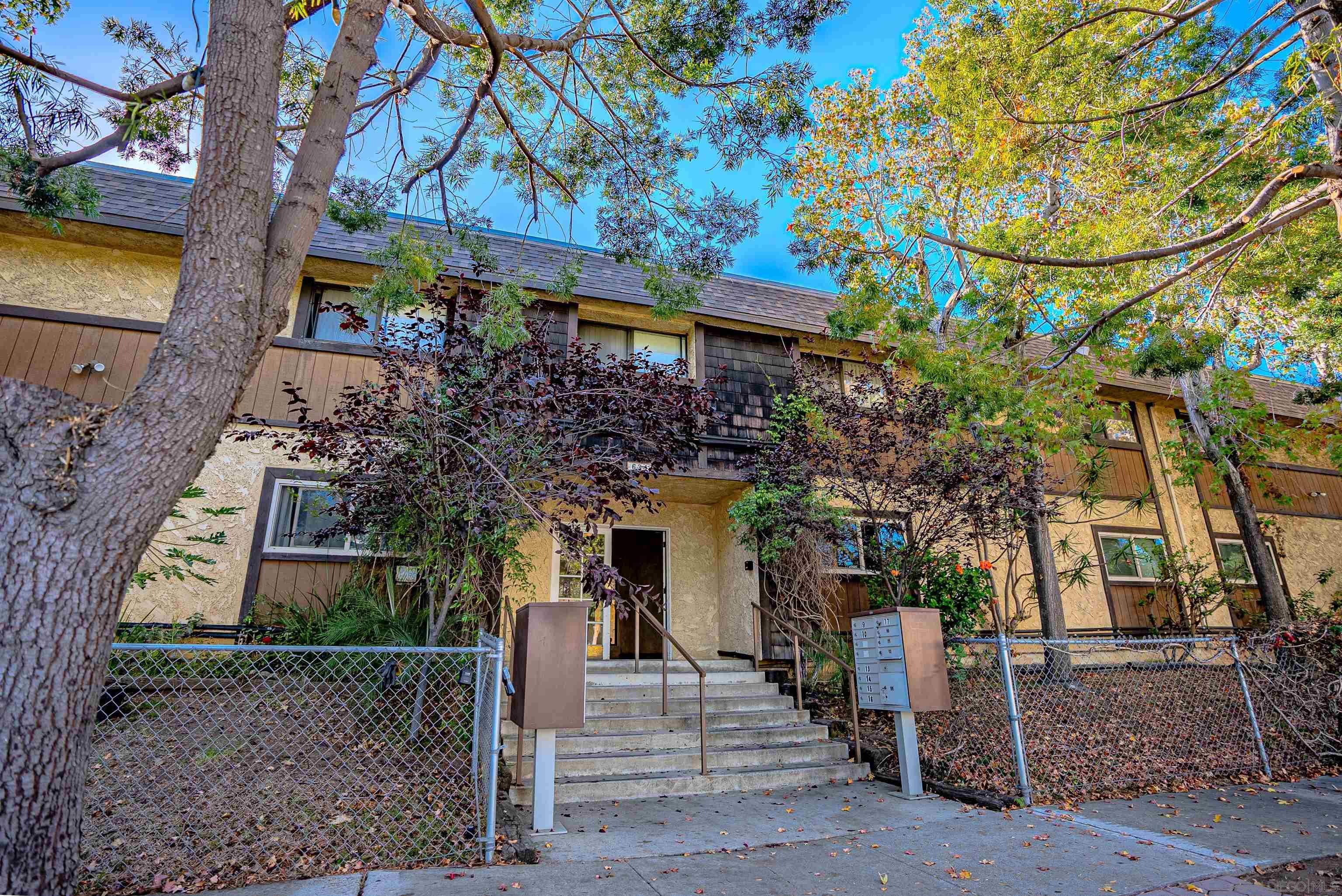 a front view of a house with a tree