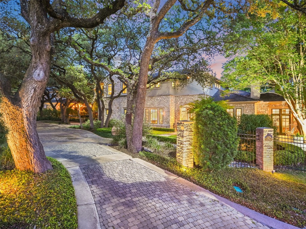 a front view of a house with a yard and an trees