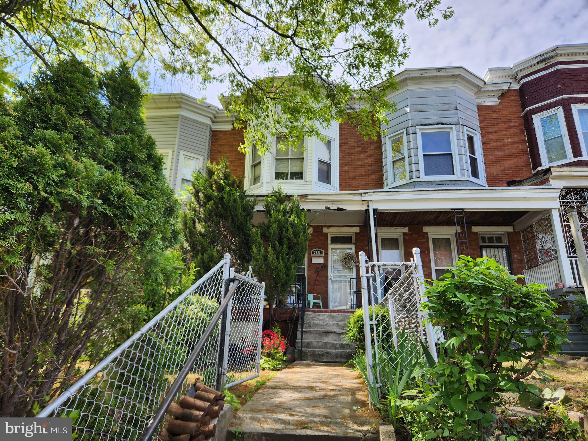 a view of a brick house with large windows and plants