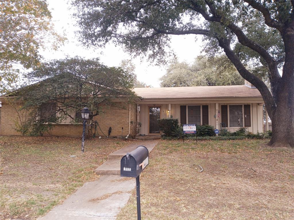 a front view of a house with garden and trees