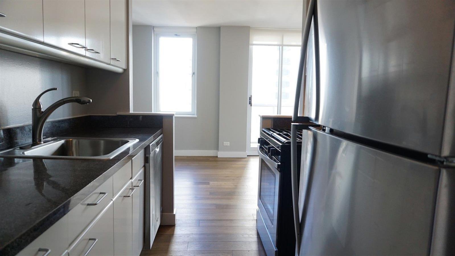 a kitchen with a refrigerator a sink and cabinets