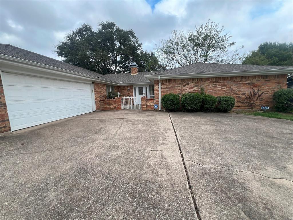 front view of a house with a yard and potted plants