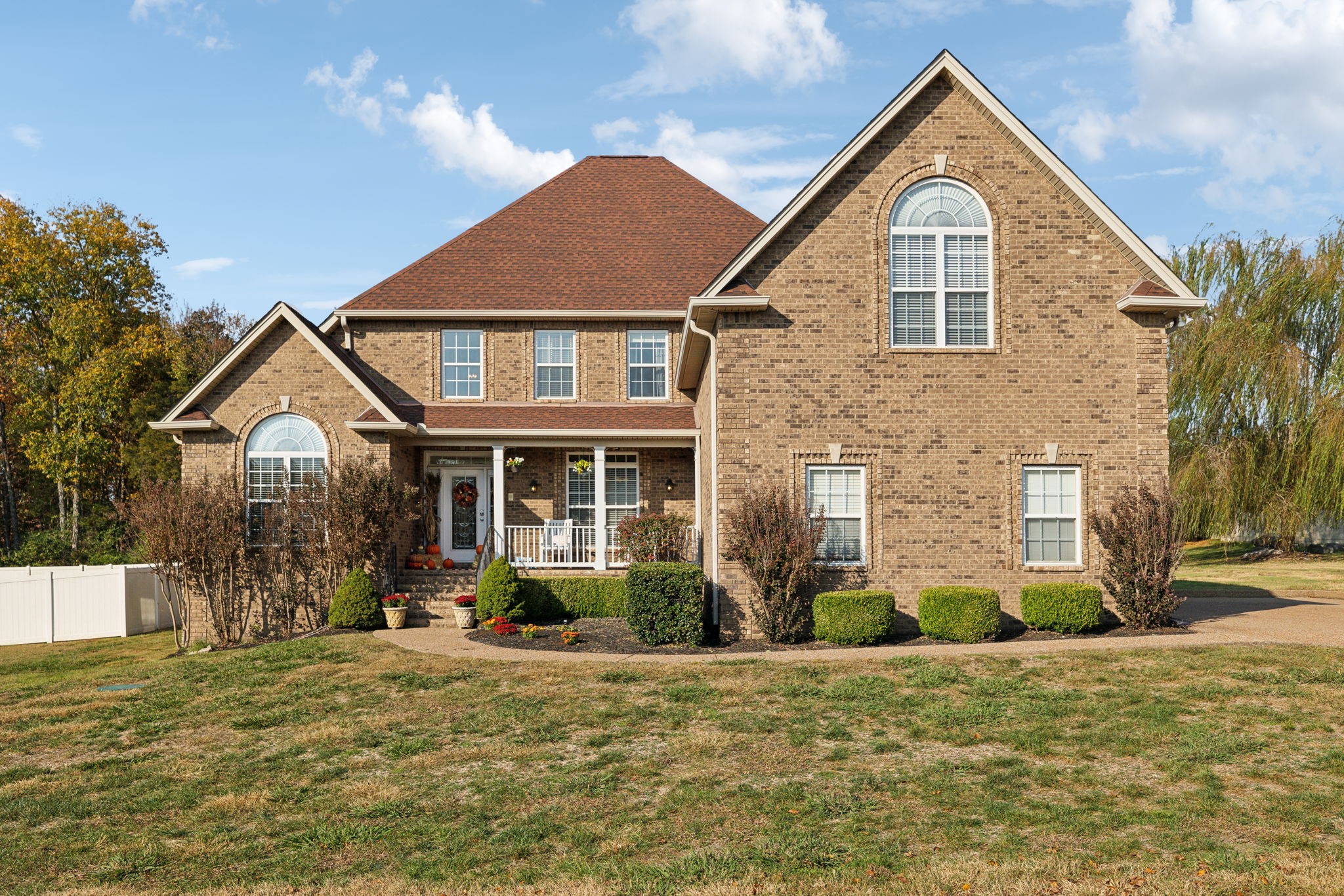 a front view of a house with a yard and potted plants