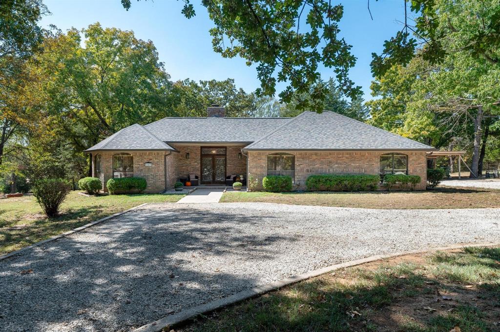 a front view of a house with a yard and trees