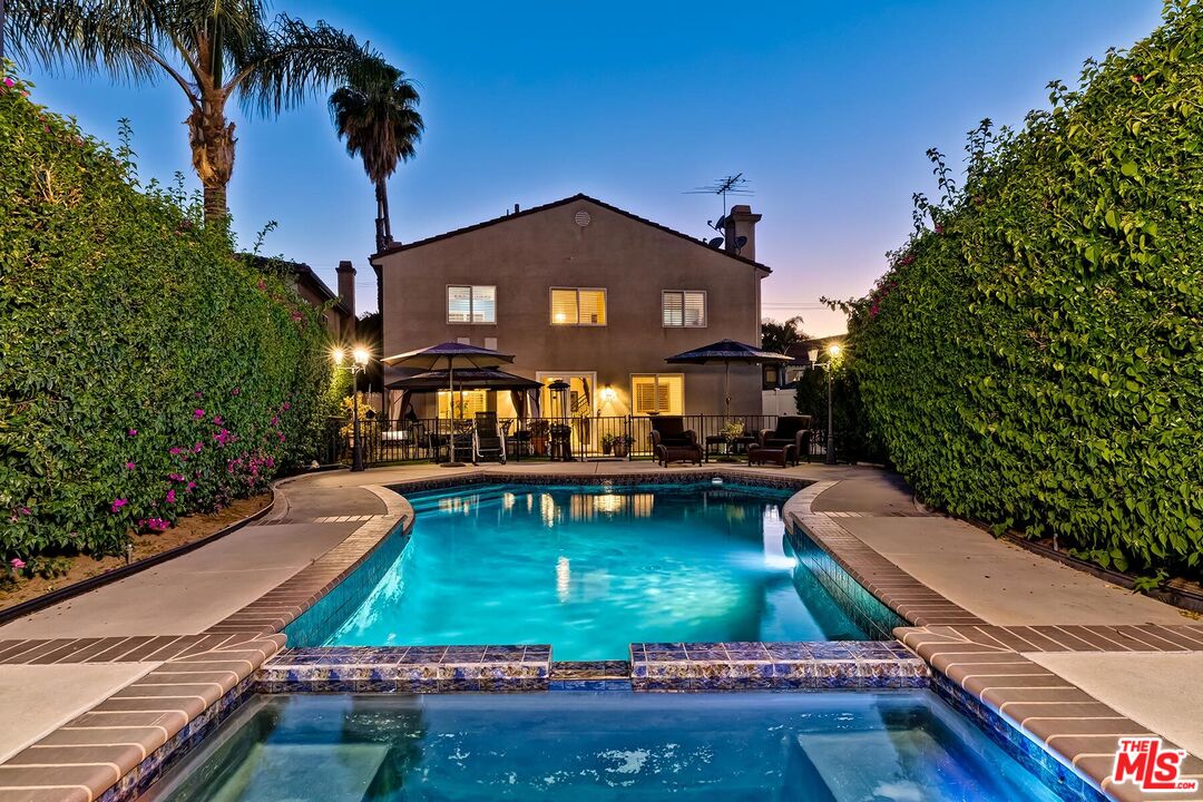 a view of a house with backyard water fountain and sitting area