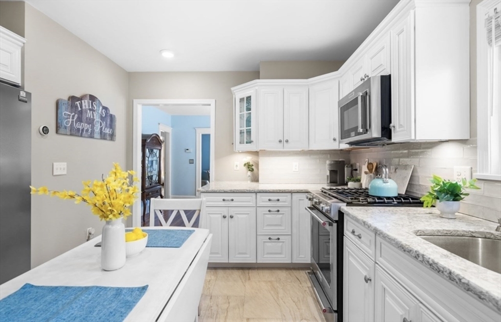 a kitchen with stainless steel appliances granite countertop a sink stove and cabinets