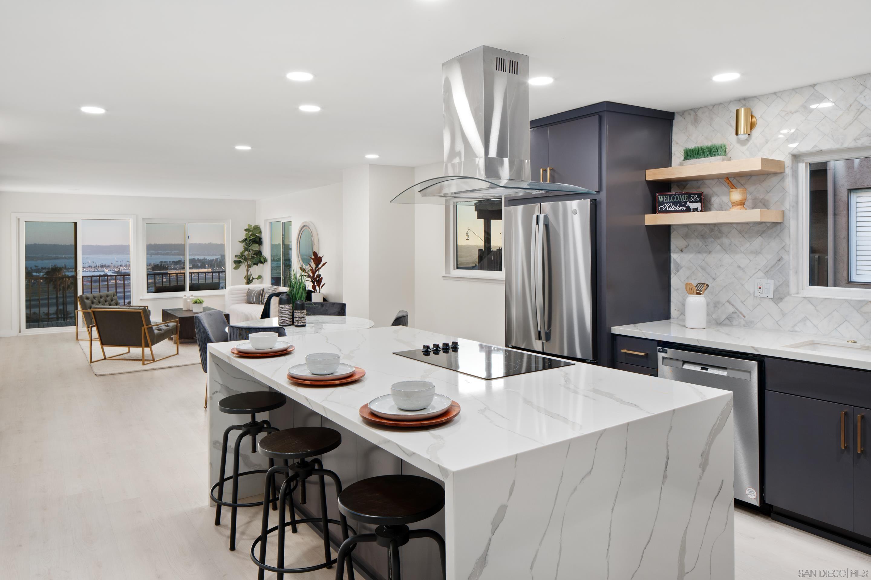 a kitchen with stainless steel appliances kitchen island granite countertop a kitchen island and chairs in it