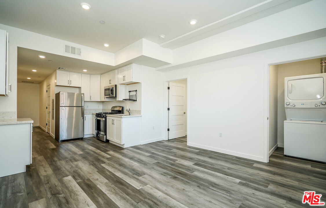 a view of kitchen with stainless steel appliances refrigerator stove microwave and cabinets